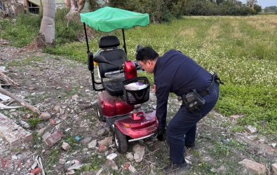 員警將重達數十公斤的電動代步車徒手抬起搬運至平坦處，並協助檢查車輛狀況。（圖／記者蘇榮泉翻攝）