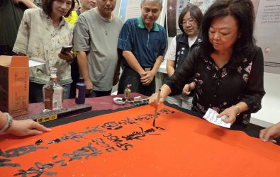 嘉義縣書法學會理事長楊貴真以得獎玉山頂級陳高入墨，揮毫為嘉酒寫雙金紅榜。(圖／記者邱嘉琪攝)