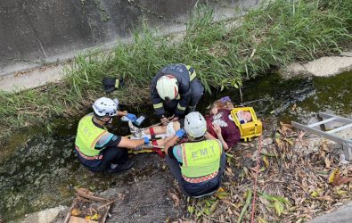 一名婦人午騎機車行經彰化市石牌國小後方大排水溝時，突然失控衝向大排，整個人瞬間噴飛到2公尺深的大排內，倒地不起。（消防局提供）