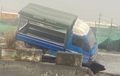 埔心鄉東溝排水防汛道路驚傳路面坍陷，一輛小貨車行經該處時，右前輪突然陷入坑洞，整車卡住無法動彈，駕駛從車窗爬出，驚險逃生。（埔心鄉公所提供）