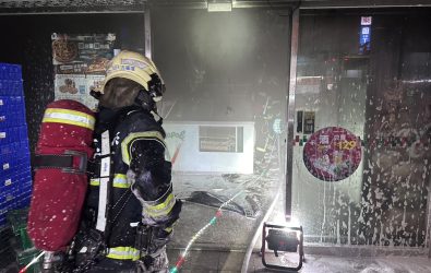彰化市中正路一家連鎖披薩店發生火警，火勢自店內迅速延燒，濃煙密布，驚醒周邊住戶，緊急逃生避難。（消防局提供）