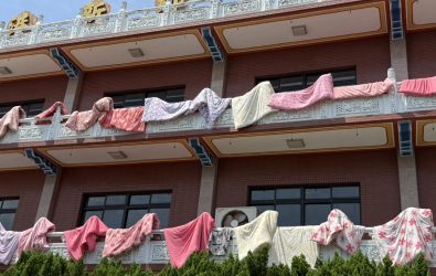 天氣一放晴，福安宮香客大樓圍牆瞬間掛滿色彩繽紛的棉被，宛如「棉被大軍」迎風招展，成為伸港鄉最吸睛的風景。（記者陳雅芳攝）