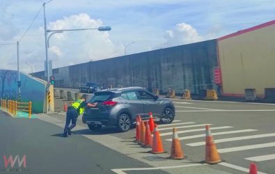 員警許志銘協同駕駛合力將故障車輛推至鄰近牛墟停車場暫置，李宇凡則在後方警戒並指揮來車，提醒駕駛人注意安全。（圖／記者蘇榮泉翻攝）